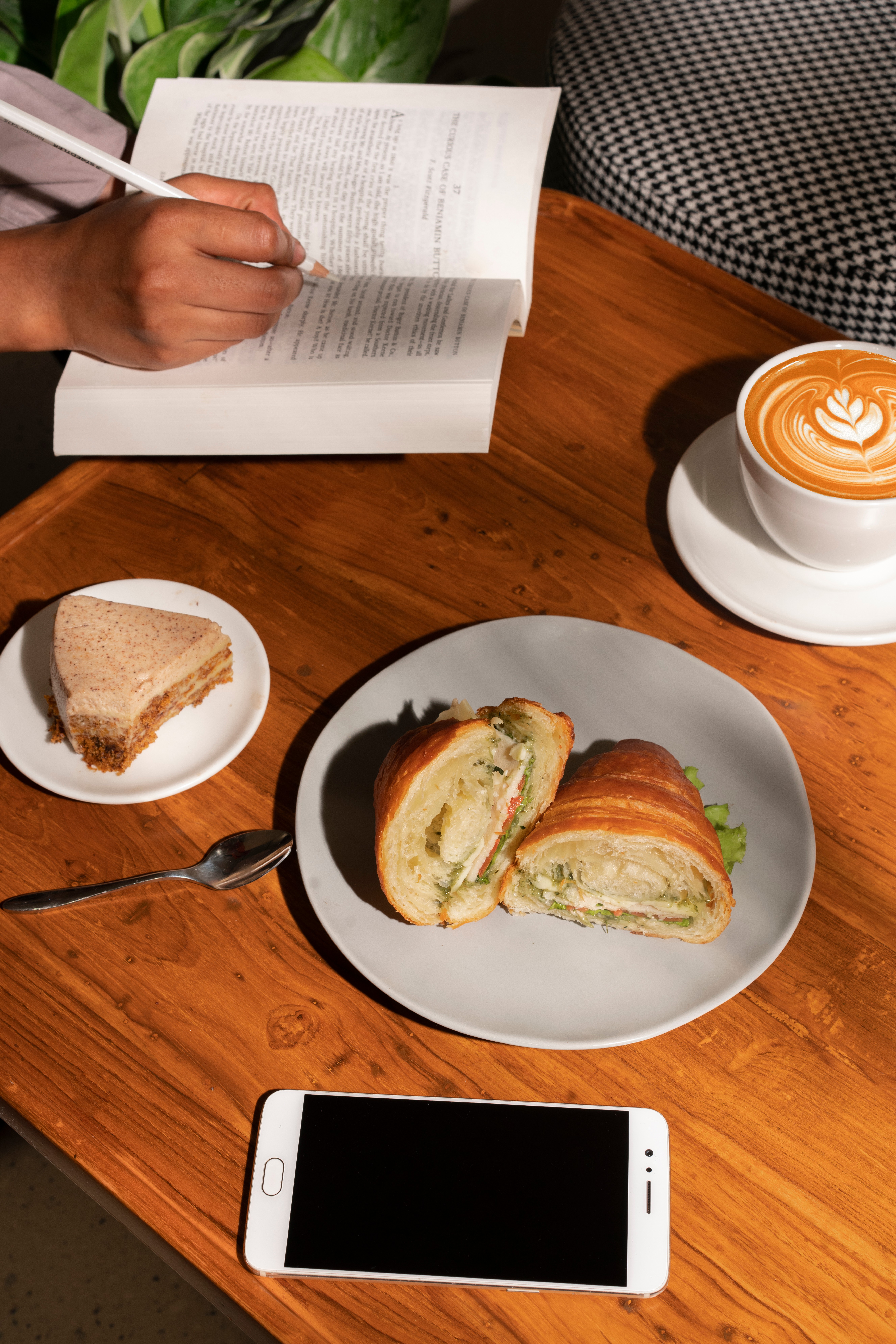 Croissant sandwich with coffee and a book at Paper and Pie